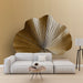 Un salon contemporain avec un papier peint représentant une grande feuille stylisée aux teintes dorées, créant une atmosphère chaleureuse et élégante.