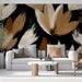 Un salon moderne avec un papier peint aux motifs de feuilles stylisées dans des teintes beige et marron sur fond noir, créant une ambiance chaleureuse et artistique.