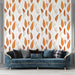 Un salon élégant avec un papier peint aux motifs de feuilles dans des teintes orange et beige sur fond clair, créant une ambiance chaleureuse et naturelle.