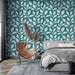 Une chambre moderne avec un papier peint turquoise orné de motifs de feuilles blanches, créant une atmosphère fraîche et apaisante.