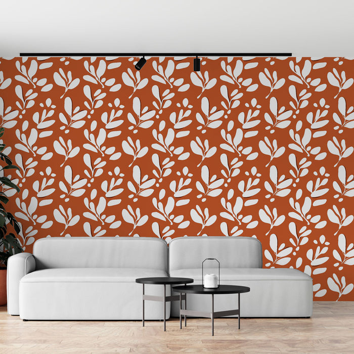 Un salon moderne avec un papier peint terracotta orné de motifs de feuilles blanches, créant une ambiance chaleureuse et accueillante.
