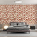 Une chambre moderne avec un papier peint aux motifs de feuilles stylisées en terracotta sur fond crème, créant une atmosphère chaleureuse et accueillante.