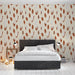 Une chambre moderne avec un papier peint aux motifs de feuilles stylisées dans des teintes rouges et blanches sur fond crème, créant une atmosphère chaleureuse et accueillante.