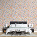 Une chambre moderne avec un papier peint aux motifs de feuilles colorées sur fond clair, créant une ambiance chaleureuse et joyeuse.