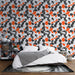 Une chambre moderne avec un papier peint aux motifs de feuilles noires et orange sur fond blanc, créant une ambiance dynamique et chaleureuse.