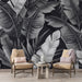 Une pièce moderne avec un papier peint tropical noir et blanc représentant de grandes feuilles stylisées, créant une atmosphère élégante et contemporaine.