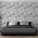 Une chambre moderne avec un papier peint aux motifs de feuilles délicates dans des teintes grises, créant une atmosphère apaisante et élégante.