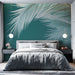 Une chambre moderne avec un papier peint tropical vert émeraude illustrant de grandes feuilles de palmier blanches, créant une atmosphère apaisante et rafraîchissante.