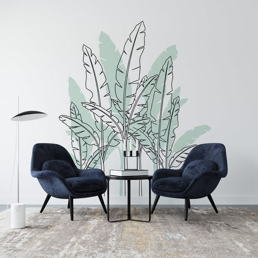 Une pièce moderne avec un papier peint représentant des feuilles de bananier stylisées en noir et vert pastel, créant une atmosphère tropicale et apaisante.