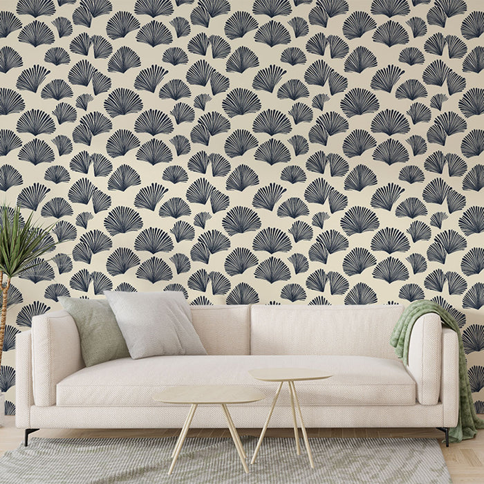Un salon élégant avec un papier peint aux motifs de feuilles stylisées bleu marine sur fond crème, créant une ambiance douce et apaisante.