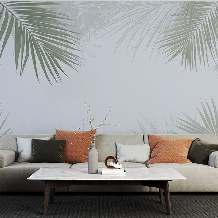 Un salon moderne avec un papier peint représentant des feuilles de palmier délicates sur fond clair, créant une ambiance apaisante et tropicale.