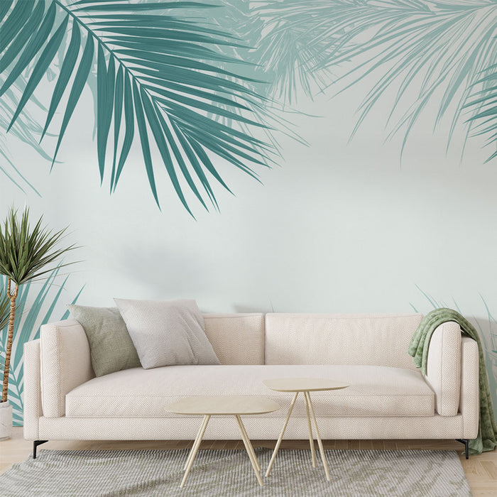 Un salon lumineux avec un papier peint tropical aux grandes feuilles de palmier turquoise sur fond clair, créant une atmosphère apaisante et naturelle.