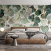 Une chambre moderne avec un papier peint aux motifs de feuilles délicates dans des teintes vertes et dorées, créant une atmosphère apaisante et naturelle.