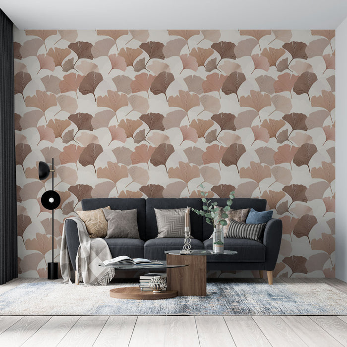 Un salon moderne avec un papier peint aux motifs de feuilles de ginkgo dans des teintes douces de rose et beige, créant une ambiance chaleureuse et naturelle.