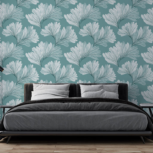 Une chambre moderne avec un papier peint aux motifs de feuilles blanches sur fond bleu-vert, créant une ambiance fraîche et apaisante.