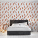 Une chambre moderne avec un papier peint aux motifs de feuilles en terracotta sur fond blanc, créant une ambiance chaleureuse et naturelle.