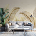 Un salon moderne avec un papier peint représentant de grandes feuilles dorées sur un fond beige, créant une ambiance élégante et chaleureuse.