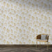 Une pièce moderne avec un papier peint aux motifs de feuilles dorées sur fond blanc, créant une atmosphère élégante et apaisante.