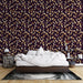 Une chambre élégante avec un papier peint floral aux motifs de feuilles dorées sur fond violet, créant une atmosphère chaleureuse et apaisante.
