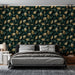 Une chambre moderne avec un papier peint aux motifs de feuilles dorées et vertes sur fond sombre, créant une atmosphère élégante et apaisante.