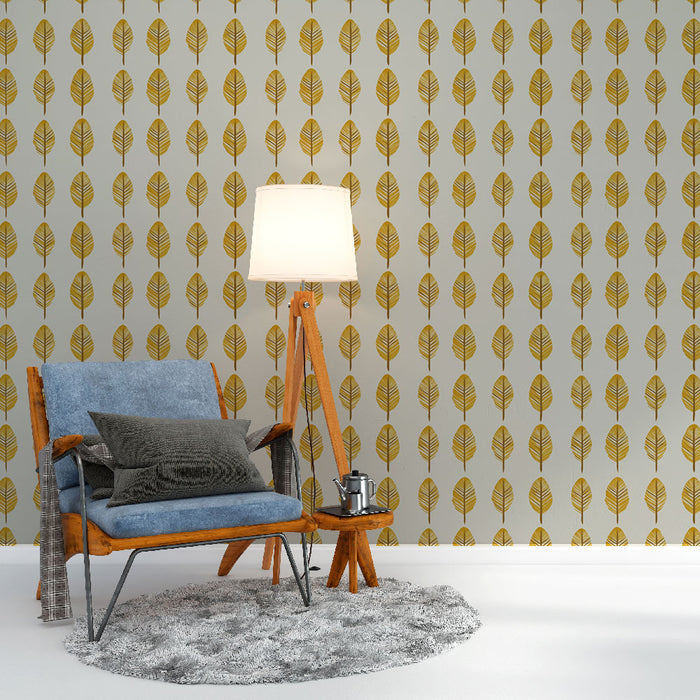 Une pièce cosy avec un papier peint aux motifs de feuilles dorées sur fond gris, créant une ambiance chaleureuse et accueillante.