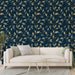 Un salon élégant avec un papier peint floral bleu nuit et doré, aux motifs de feuilles délicates, créant une ambiance raffinée et apaisante.