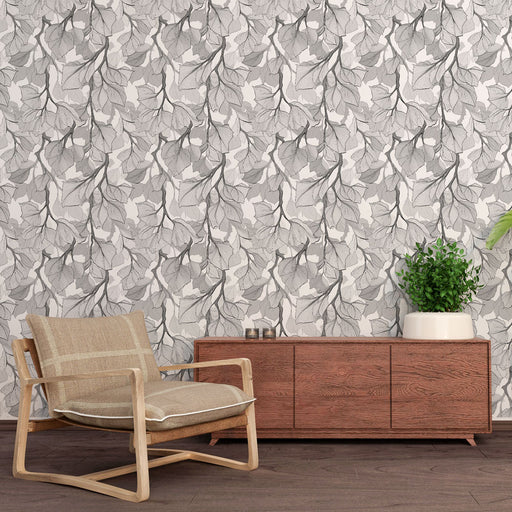 Une salle de séjour avec un papier peint aux motifs de feuilles délicates en nuances de gris, créant une atmosphère apaisante et élégante.