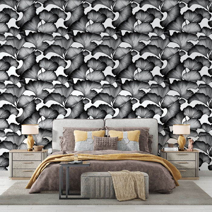 Une chambre élégante avec un papier peint noir et blanc représentant des feuilles stylisées, créant une atmosphère artistique et moderne.