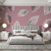 Une chambre moderne avec un papier peint rose pâle orné de grandes feuilles noires, créant une atmosphère douce et apaisante.