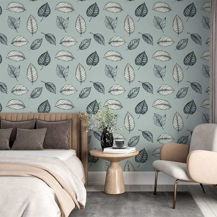 Une chambre élégante avec un papier peint aux motifs de feuilles délicates en noir et blanc sur fond bleu clair, créant une atmosphère apaisante et naturelle.