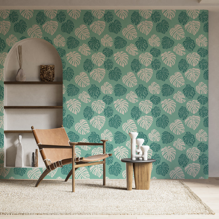 Une pièce lumineuse avec un papier peint tropical vert menthe orné de grandes feuilles de monstera, créant une ambiance fraîche et naturelle.