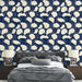 Une chambre moderne avec un papier peint navy aux motifs de feuilles stylisées crème, créant une ambiance apaisante et élégante.