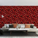 Un salon moderne avec un papier peint aux motifs de feuilles rouges sur fond noir, créant une ambiance chaleureuse et dynamique.