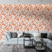 Un salon contemporain avec un papier peint floral aux motifs de feuilles orange sur fond blanc, créant une ambiance chaleureuse et accueillante.
