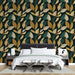Une chambre moderne avec un papier peint aux motifs de feuilles stylisées dans des teintes vert foncé, doré et beige, créant une atmosphère chaleureuse et naturelle.