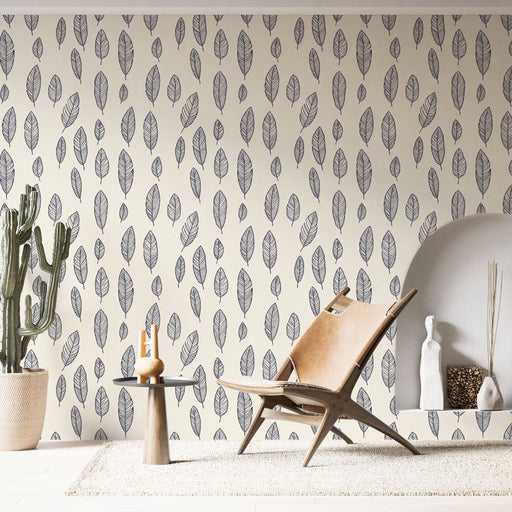 Une pièce moderne avec un papier peint aux motifs de feuilles délicates en noir sur fond beige, créant une atmosphère apaisante et naturelle.