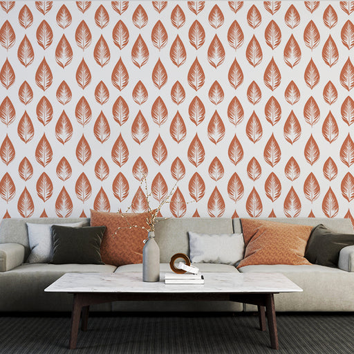 Un salon moderne avec un papier peint aux motifs de feuilles terracotta sur fond blanc, créant une ambiance chaleureuse et naturelle.