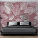 Une chambre moderne avec un papier peint aux motifs de feuilles blanches sur fond rose, créant une atmosphère douce et apaisante.