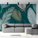 Un salon moderne avec un papier peint représentant de grandes feuilles stylisées sur fond vert émeraude, créant une atmosphère apaisante et naturelle.