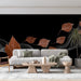 Un salon contemporain avec un papier peint noir orné de feuilles stylisées en cuivre et des lignes délicates, créant une ambiance chic et apaisante.
