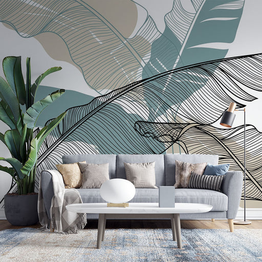 Un salon moderne avec un papier peint représentant de grandes feuilles stylisées en noir et des teintes douces de bleu et beige, créant une ambiance apaisante et élégante.