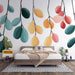 Une chambre moderne avec un papier peint illustrant des feuilles stylisées aux teintes pastel, créant une atmosphère joyeuse et apaisante.