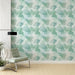 Une pièce lumineuse avec un papier peint aux motifs de feuilles délicates dans des teintes de vert et bleu, créant une ambiance apaisante et naturelle.