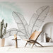Une pièce moderne avec un papier peint tropical représentant de grandes feuilles stylisées en noir sur fond clair, créant une ambiance fraîche et apaisante.