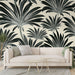 Un salon contemporain avec un papier peint tropical noir et blanc représentant de grandes feuilles exotiques sur un fond clair, créant une atmosphère élégante et apaisante.