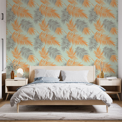 Une chambre moderne avec un papier peint tropical aux motifs de feuilles dans des teintes orange et grise sur fond vert clair, créant une atmosphère fraîche et vivante.