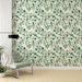 Un salon moderne avec un papier peint floral représentant des feuilles vertes délicates sur fond clair, créant une atmosphère apaisante et naturelle.