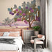Une chambre moderne avec un papier peint illustrant un arbre fruitier aux teintes violettes et vertes, créant une atmosphère douce et apaisante.