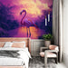 Une chambre moderne avec un papier peint tropical représentant un flamant rose majestueux sur fond dégradé de violet et d'orange, créant une atmosphère sereine et exotique.