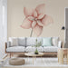 Un salon moderne avec un papier peint représentant une grande fleur stylisée aux lignes délicates dans des teintes rose et beige, créant une atmosphère douce et accueillante.